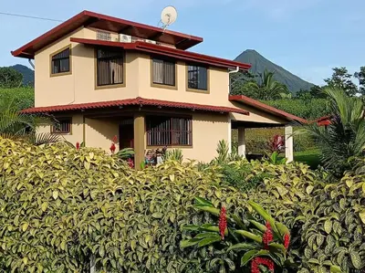 a house in the middle of a field of plants at Arenal Dreams House in Fortuna