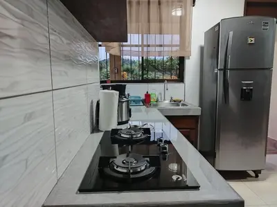a kitchen with a stove and a stainless steel refrigerator at Arenal Dreams House in Fortuna