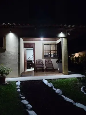 a house with two chairs and a patio at night at Arenal Dreams House in Fortuna