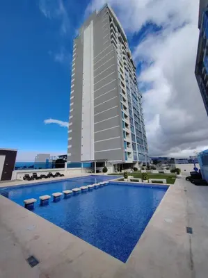 a large building with a swimming pool in front of a building at Elegante apartamento en ciudad in San José