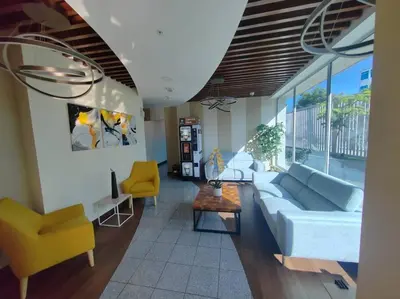 a living room with a blue couch and yellow chairs at Elegante apartamento en ciudad in San José