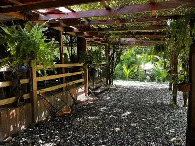 a pergola with potted plants and a fence at Bamboo River Lodge in Horquetas