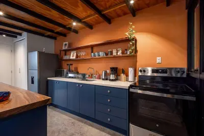 a kitchen with blue cabinets and a black stove at Casa Mariola the blissful studio in Mal País