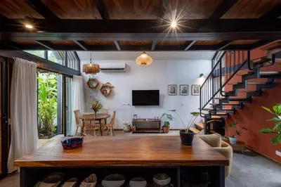 a living room with a large wooden table and stairs at Casa Mariola the blissful studio in Mal País