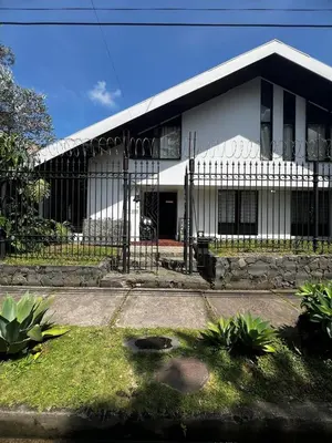 a white building with a gate in front of it at Casa Aldaba in San José