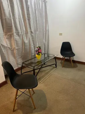 two chairs and a glass table with a vase on it at Casa Aldaba in San José