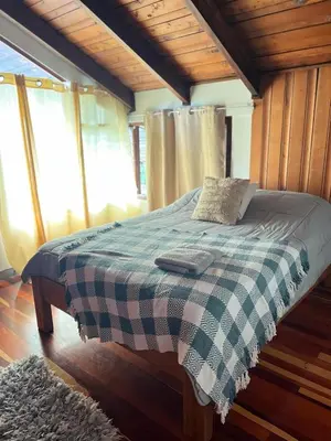 a bedroom with a bed with a checkered blanket at Casa Aldaba in San José