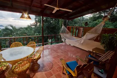 a patio with a table and chairs and a hammock at Hotel Villas Nicolas - Adults Only in Manuel Antonio