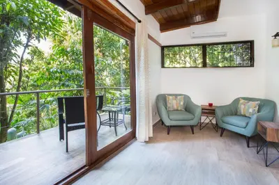 a screened in porch with two chairs and a television at Hotel Villas Nicolas - Adults Only in Manuel Antonio