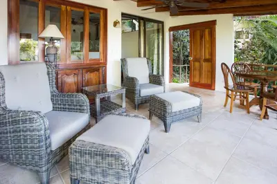 a screened porch with chairs and a table and a tableablish at Hotel Villas Nicolas - Adults Only in Manuel Antonio
