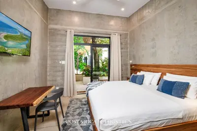 a bedroom with a bed and a desk and a window at Steps to the Main Surf Break - Casita 1 Dos Hijas in Refundores