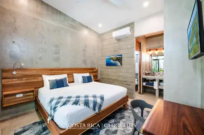 a bedroom with a bed and a desk in a room at Steps to the Main Surf Break - Casita 1 Dos Hijas in Refundores