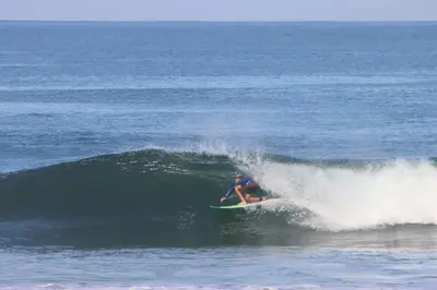 a person riding a wave on a surfboard in the ocean at Steps to the Main Surf Break - Casita 1 Dos Hijas in Refundores
