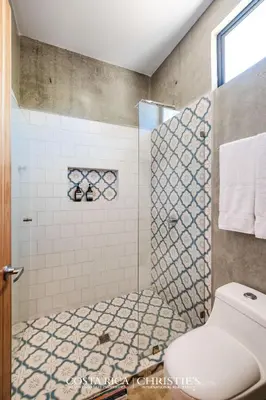 a bathroom with a white toilet and a shower at Steps to the Main Surf Break Casita 2 Dos Hijas in Refundores