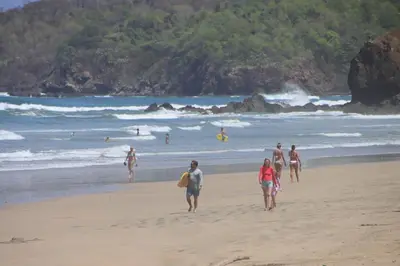 a group of people walking on the beach at Steps to the Main Surf Break Casita 2 Dos Hijas in Refundores