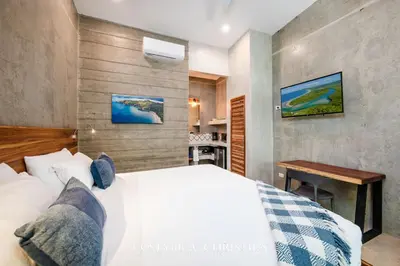 a bedroom with a white bed and a desk at Steps to the Main Surf Break Casita 2 Dos Hijas in Refundores