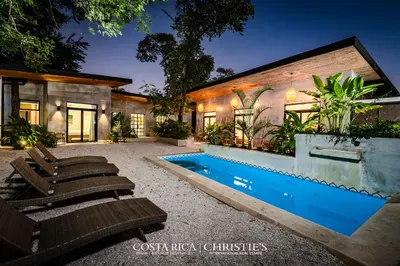 a house with a swimming pool next to a house at Steps to the Main Surf Break - 3 Bedroom House in Refundores