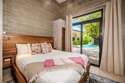 a bedroom with a bed and a large window at Steps to the Main Surf Break - 3 Bedroom House in Refundores