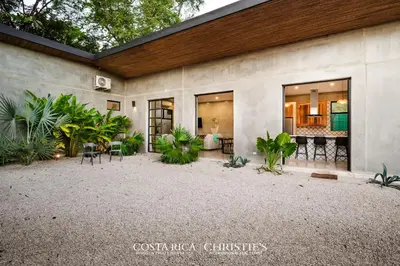 a house with a courtyard with chairs and plants at Steps to the Main Surf Break - 3 Bedroom House in Refundores