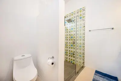 a bathroom with a toilet and a glass shower at Villa Serenity 6 bedroom - 1 minute to the beach in Santa Cruz
