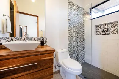a bathroom with a white toilet and a sink at Villa Serenity 6 bedroom - 1 minute to the beach in Santa Cruz