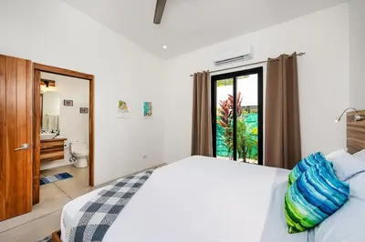 a bedroom with a bed and a bathroom with a window at Villa Serenity 6 bedroom - 1 minute to the beach in Santa Cruz