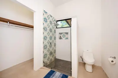 a bathroom with a toilet and a window at Villa Serenity 6 bedroom - 1 minute to the beach in Santa Cruz