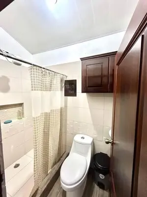a small bathroom with a toilet and a shower at Miravalles Country House in Guayabal