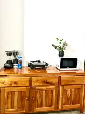 a wooden cabinet with a microwave and a laptop on it at Miravalles Country House in Guayabal