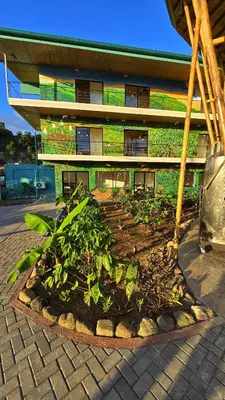 a building with a garden in front of it at Bonding Coffee Roaster Café & Hotel in Quepos