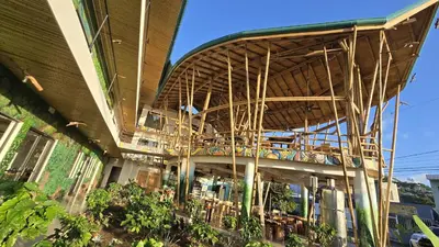 a building with a tables and chairs under a roof at Bonding Coffee Roaster Café & Hotel in Quepos