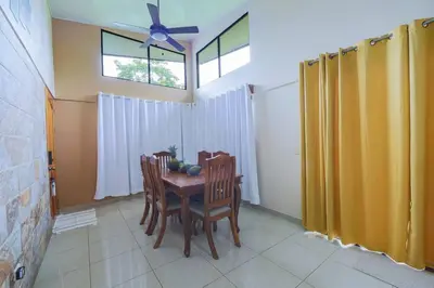 a dining room with a table and chairs and a window at La Casa Amarilla in Fortuna