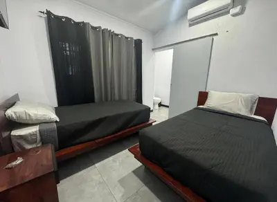 a bedroom with two beds and a window in it at Casa Tusi - 2 Blocks From Clubs & Strip in Jacó