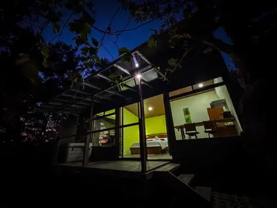a house with a light on the porch at night at Monte Green Villa Romántica con jacuzzi in Monteverde Costa Rica