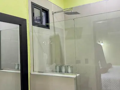 a glass shower in a bathroom with a mirror at Monte Green Villa Romántica con jacuzzi in Monteverde Costa Rica