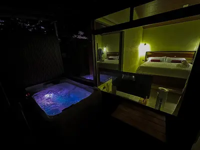 a dark room with a tub in a bedroom at Monte Green Villa Romántica con jacuzzi in Monteverde Costa Rica