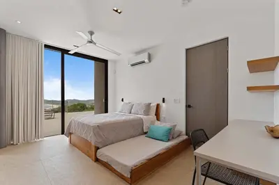a bedroom with a bed and a couch and a window at Amazing Ocean and Mountain Views in Tamarindo