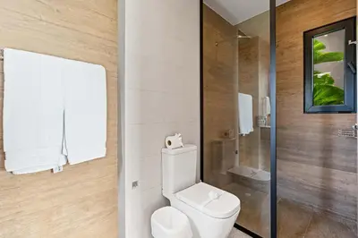a white bathroom with a toilet and a shower at Amazing Ocean and Mountain Views in Tamarindo