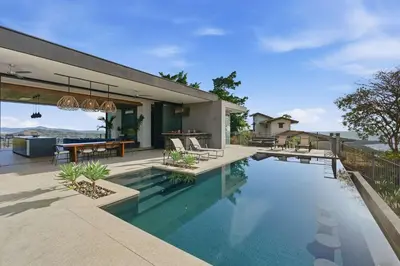 a house with a swimming pool and a patio at Amazing Ocean and Mountain Views in Tamarindo