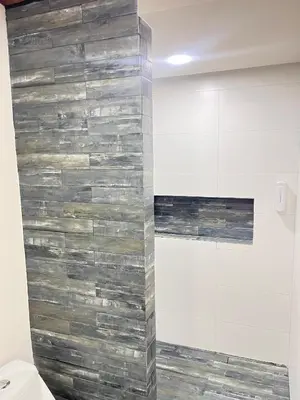 a bathroom with a stone wall next to a toilet at Marea Baja73 in Puntarenas