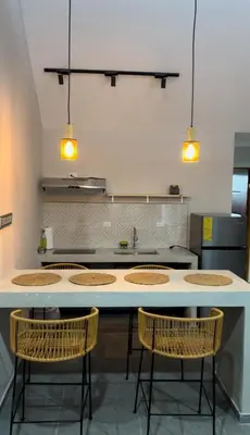 a kitchen with four chairs and a counter with a sink at Marea Baja73 in Puntarenas