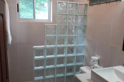 a bathroom with a shower with glass block walls at #8 Ocean view Beach Front Bungalow 2nd Row in Playa Hermosa