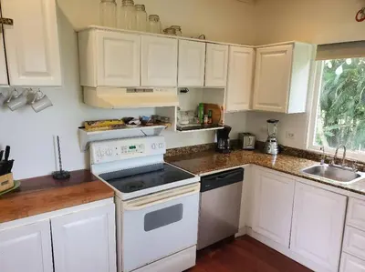 a kitchen with white cabinets and a stove top oven at #8 Ocean view Beach Front Bungalow 2nd Row in Playa Hermosa