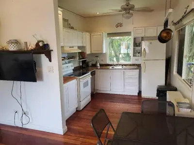 a kitchen with white cabinets and a wooden floor at #8 Ocean view Beach Front Bungalow 2nd Row in Playa Hermosa