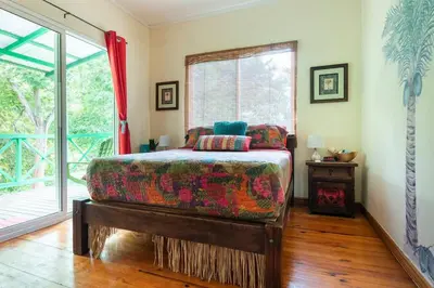 a bedroom with a bed and a large window at #28 Beach Bungalow in Playa Hermosa