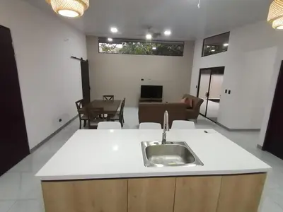 a kitchen with a sink and a living room at Casa Pacifica in Uvita
