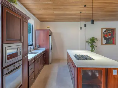 a kitchen with wooden cabinets and a counter top at Surfside Apartments - Playa Mar Azul in Mal País