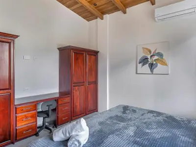 a bedroom with a desk and a bed and a deskictericter at Surfside Apartments - Playa Mar Azul in Mal País