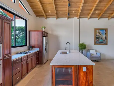 a kitchen with wooden cabinets and a counter top at Surfside Apartments - Playa Mar Azul in Mal País