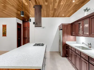 a kitchen with wooden cabinets and a white counter top at Surfside Apartments - Playa Mar Azul in Mal País